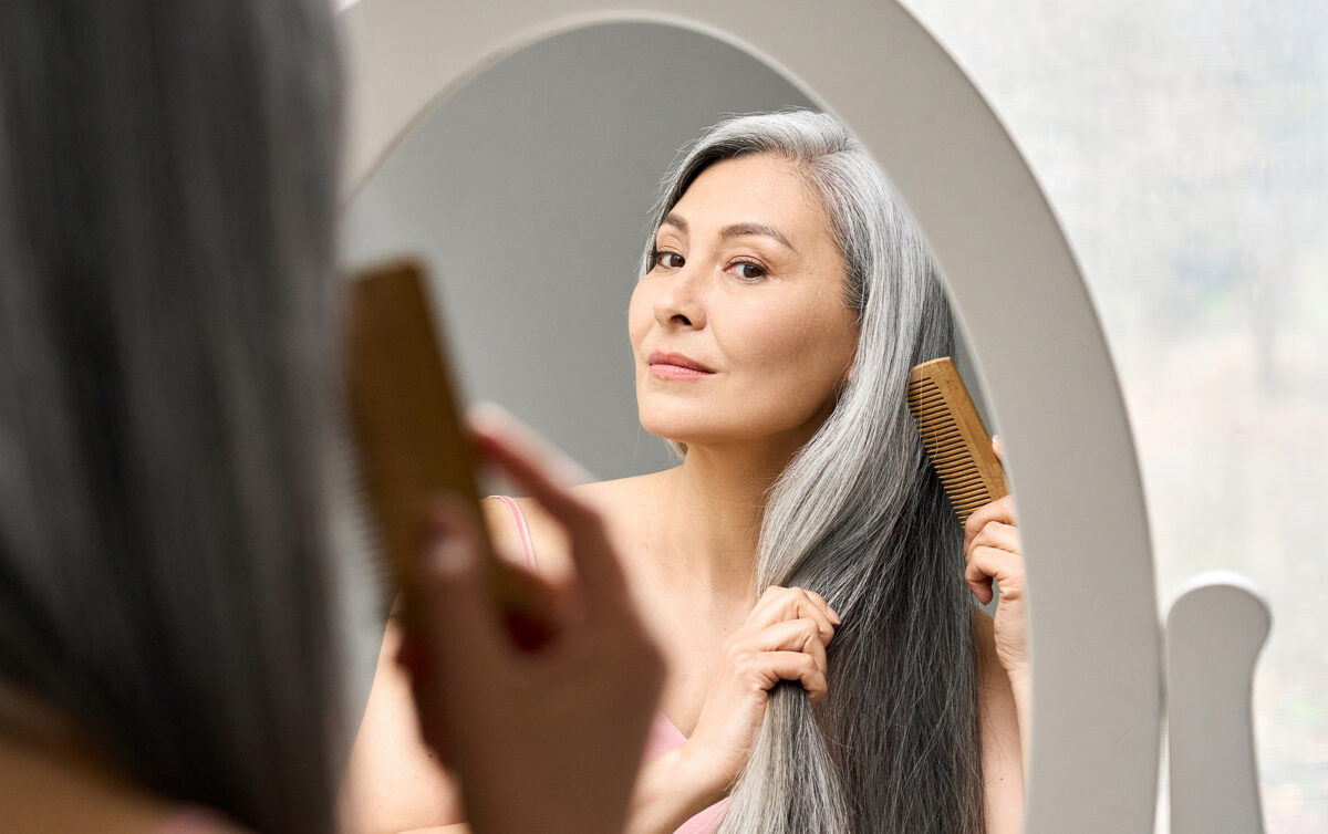 woman brushing hair taking hormone replacement therapy