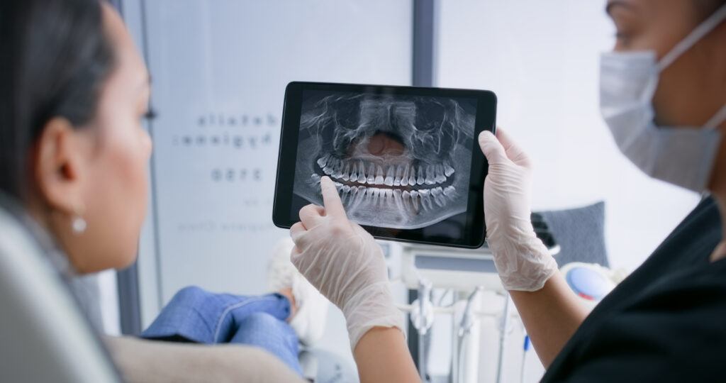 dentist showing patient x-ray of condition of teeth