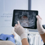 dentist showing patient x-ray of condition of teeth